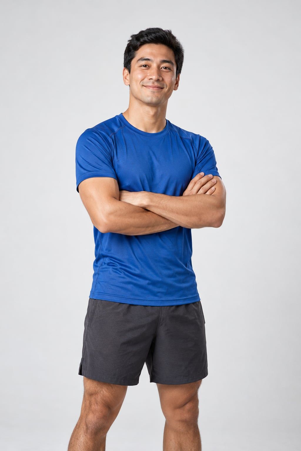Hiro, homem de ascendência japonesa com camiseta de corrida azul, de braços cruzados num fundo branco